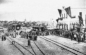טקס חנוכת מסילת הרכבת יפו–ירושלים – הרכבת הראשונה נכנסת לתחנת הרכבת ירושלים המקושטת בדגלי האימפריה העות'מאנית.