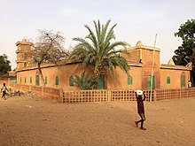 un bâtiment Orange aux portes et fenêtres verte