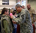 A member of the Oregon State Defense Force helps a child try on body armor.