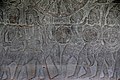 Soldiers carry drums and a shoulder-mounted nipple gong in relief at Angkor Wat.