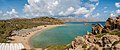 Panorama of Vai beach from the southern headland showing the roof of the restaurant, the sun shelters, the northern headland and pigeon rocks.