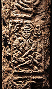 A figure, perhaps cross-legged and horned, on the north cross at Clonmacnoise.