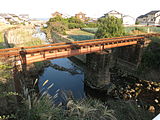 単線上路デッキガーダー橋（単純桁橋）島原鉄道。中央の橋脚の両側に高さの違う2本の桁橋が架かっている。