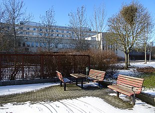 Parken med sittplatser i öster och sjukhuset i fonden.