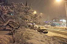 An avenue in Istanbul, with a considerable amount of snow, both on the ground and on the roads. Snow is also falling and visibility is very low.