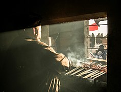 A man grilling meat to serve the Arba'in pilgrims