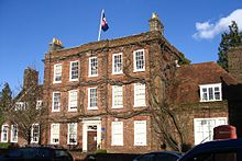A three-storey red brick Georgian building with central main door and 14 deep regularly-spaced windows