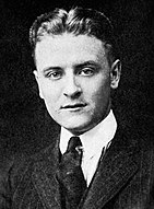 Photograph of F. Scott Fitzgerald as a student at Princeton. The photo features only his head and shoulders. He is wearing a dark tie and a pin-striped suit. His hair is parted in the middle and neatly coiffed.