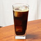 dark brown cocktail on ice in a tall glass
