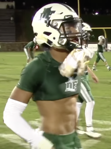 Hyatt in high school wearing his helmet on a football field