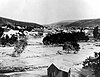 A black and white photograph of water rushing through the small town of Heppner.