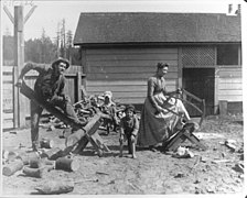 The Titus family sawing wood