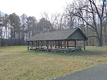 A large open wooden structure in a field