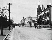 德占时期1910年代初的中山路，中央为南墙写有伊尔蒂斯泉与罗斯洋行书店广告的奥古斯特·迈尔商业楼，其左侧为水师饭店，右侧为瓦格纳时装店与中山路17号近代建筑