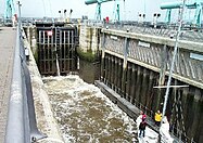 A lock used for boat navigation with a low level of water near Cardiff Bay.