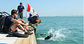  A diver enters the water watched by the supervisor and standby diver, with warning flags flying