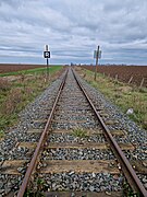 Vue de la ligne depuis le PN 33, sur sa section encore exploitée entre Pithiviers et Engenville.