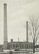 A one-story brick powerhouse with two chimneys