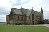 A stone chapel with a transept and an octagonal bell turret