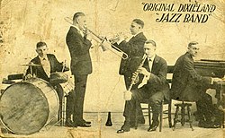 1918 promotional postcard of the ODJB showing (from left), drummer Tony Sbarbaro (aka Tony Spargo), trombonist Edwin "Daddy" Edwards, cornetist Dominick James "Nick" LaRocca, clarinetist Larry Shields, and pianist Henry Ragas
