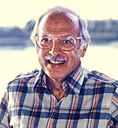 A grey-haired man wearing eyeglasses