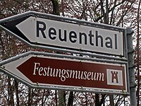 Direction signs for a minor route to a destination (white) and tourist attraction (brown) in Switzerland.