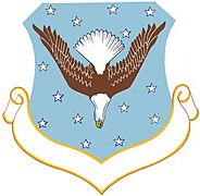 Un águila Volante recursante descendiente en pálido, el emblema de la 38° División Aérea de la Fuerza Aérea de los EE.UU.