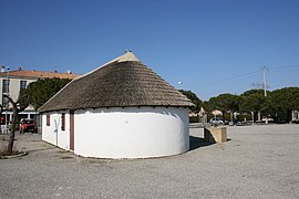 Arrière maçonné en abside sous croupe de roseau.