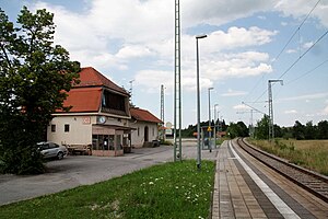 Single-tracked platform next to two-story building with half-hipped roof