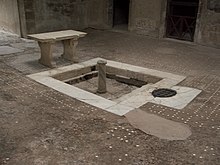 sol avec un bassin carré bordé de dalles blanches et une table en pierre blanche