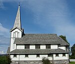 Bild einer weißen Holzkirche mit dunklem Dach.