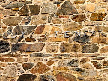 Iron letters on the east wall of the church dating from 1698, spelling in Latin "LUX-L.I. TENEBR ORIENS- EX ALTO" which translates to "Light from on high shines in the darkness"