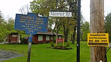 a picture of the sign next to a street sign for Maverick Road