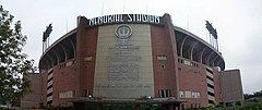 A large stadium, with flags flying off of it