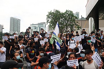 Protesters with messages saying "Please liberate Hong Kong" (with some messages having the words "President Trump" in front), and in the lower lines in Chinese and English: "Defend Hong Kong Constitution". One man is holding the flag of Jerusalem Municipality in the background.