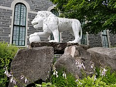 Lion de ciment sur le côté nord-est de l'église de Sainte-Thècle façonné par le curé Maxime Masson.