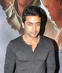 Suriya in a dark, long-sleeved shirt posing for the camera