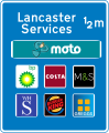 Approach sign to motorway service area listing operator and six franchises available at the stop. These are the only signs allowed to display brand logos.