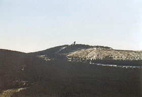 Vue du sommet avec, sur son versant, une voie ferrée et au sommet un tremplin à ski.