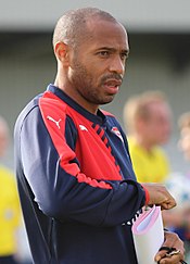 A dark-skinned man wearing a coat