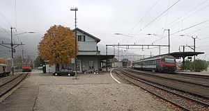 Two-story building with gabled roof between two sets of railway lines