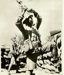 Chinese soldier wearing a German helmet holding an M24-style grenade