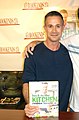 Photo d'un homme qui tiens un livre de cuisine.