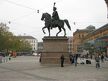 Statue équestre sur une place.