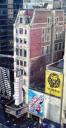 The front of the New Amsterdam Theatre, an 11-story structure with a stone facade on 42nd Street and a brick facade on the side, seen from a nearby building