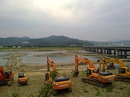 금호강 지류 정비공사를 위해 중장비들이 대기하고 있는 모습.