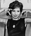 Singer and actress Barbra Streisand in 1962 wearing a top with a crew-neck. Her hair is teased at the crown.