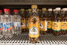 Bottles of Champis on a store shelf, on the left are bottles of Loka, on the right bottles of Trocadero.