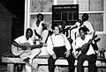 Régulo Ramírez ensayando un número con un grupo musical nativo de San Andrés, durante el rodaje de Isla de Ensueño. Al fondo se ve el tablero de instrucciones diarias de la Productora.