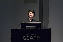 Kaijima giving a lecture in front of a podium